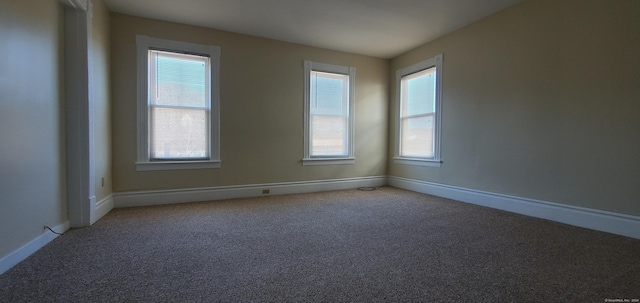 unfurnished room featuring baseboards and light carpet