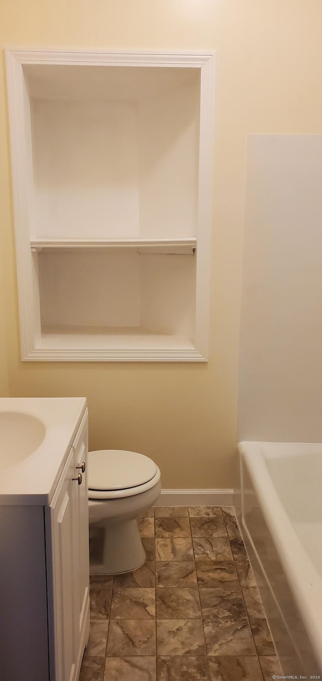 full bath with a washtub, toilet, vanity, and baseboards