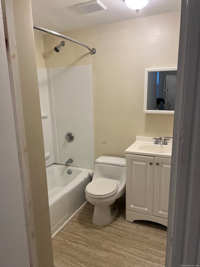 full bathroom with vanity, toilet, hardwood / wood-style flooring, and shower / tub combination