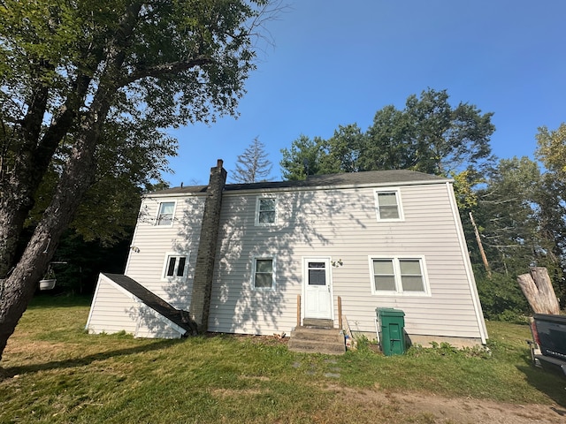 rear view of property featuring a lawn