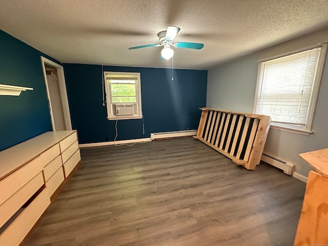 unfurnished bedroom featuring baseboard heating, ceiling fan, dark hardwood / wood-style floors, and a textured ceiling