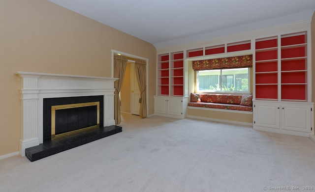 unfurnished living room with built in shelves, light colored carpet, and a fireplace