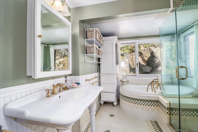 bathroom featuring tile patterned flooring, shower with separate bathtub, and sink