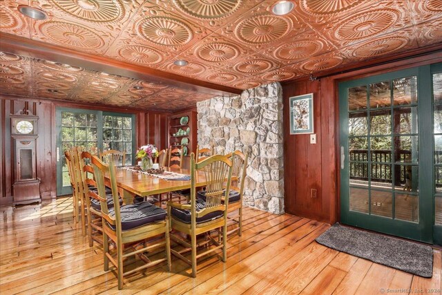 dining area featuring wood walls and light hardwood / wood-style floors