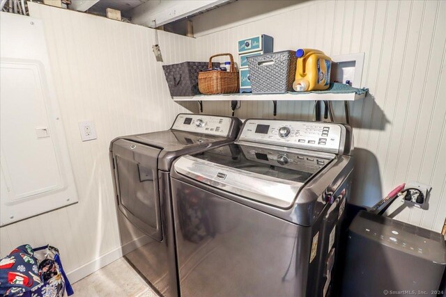 washroom featuring wood walls and independent washer and dryer