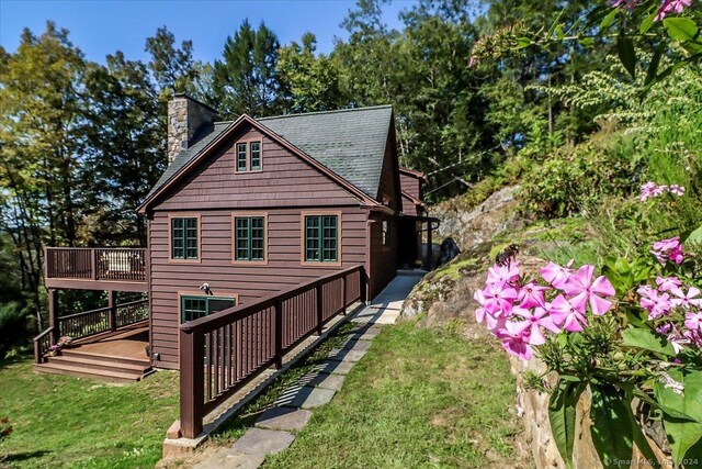 view of side of home with a lawn and a deck