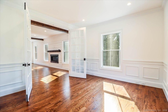 unfurnished living room with beam ceiling, french doors, ornamental molding, and hardwood / wood-style flooring