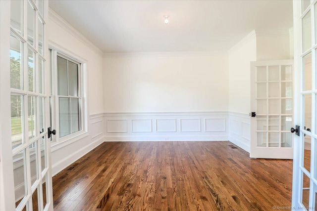 empty room with french doors, dark hardwood / wood-style flooring, plenty of natural light, and crown molding