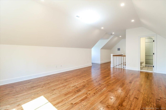 additional living space with lofted ceiling and light wood-type flooring