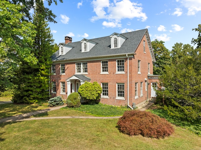 colonial inspired home featuring a front lawn