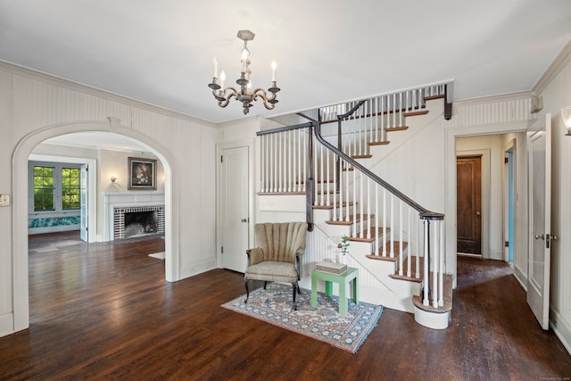 interior space featuring crown molding, a fireplace, hardwood / wood-style floors, and a chandelier