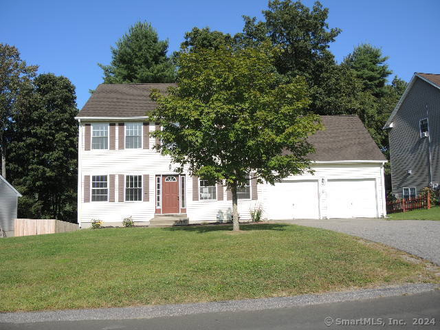 colonial-style house with a garage and a front lawn