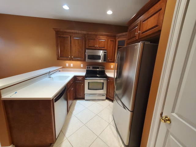 kitchen with appliances with stainless steel finishes, light tile patterned floors, and sink