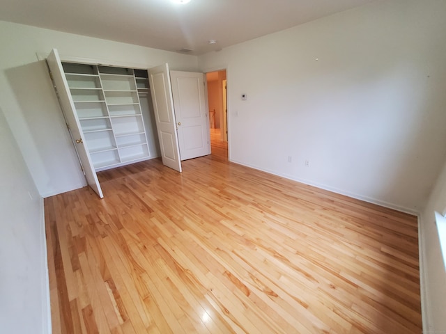 unfurnished bedroom with a closet and light wood-type flooring