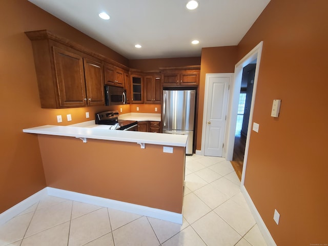 kitchen with a breakfast bar, kitchen peninsula, stainless steel appliances, and light tile patterned floors