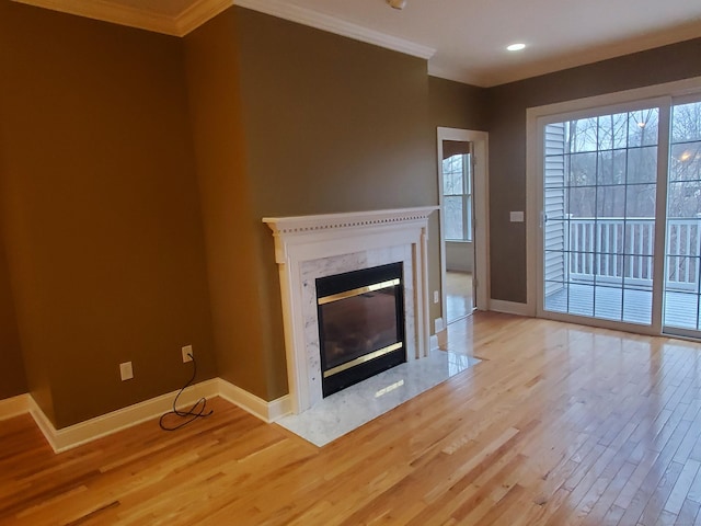 unfurnished living room featuring crown molding, light hardwood / wood-style flooring, and a high end fireplace