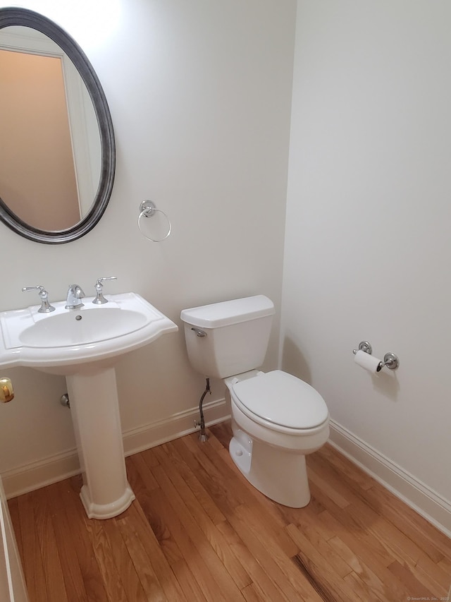 bathroom with hardwood / wood-style floors and toilet