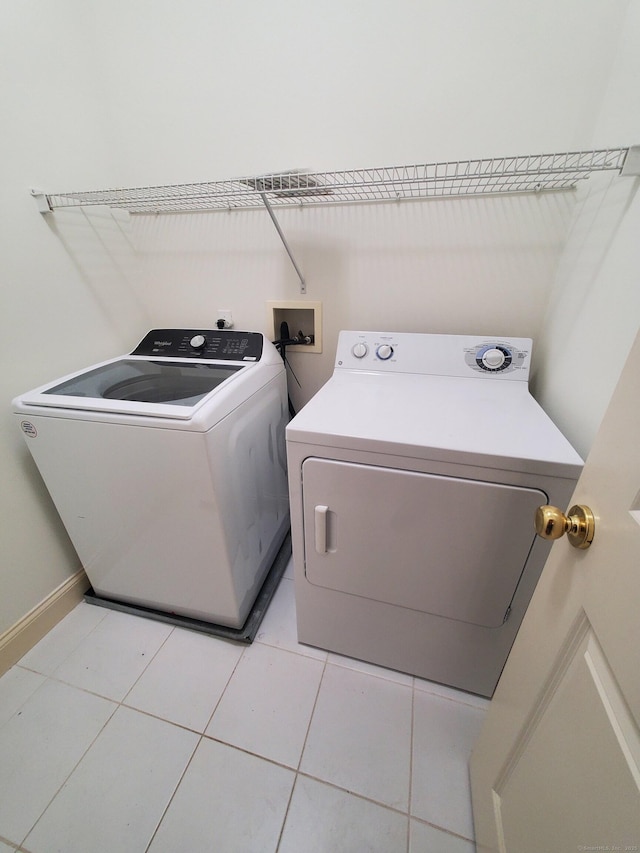 washroom featuring washing machine and dryer and light tile patterned floors