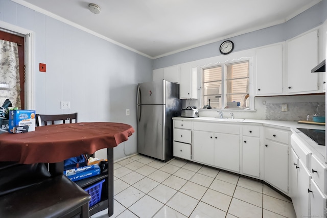 kitchen featuring white cabinets, decorative backsplash, stainless steel fridge, and crown molding