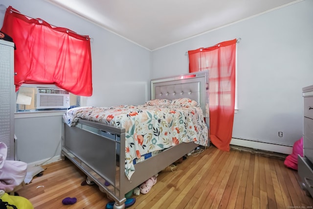 bedroom with hardwood / wood-style floors, a baseboard radiator, cooling unit, and crown molding