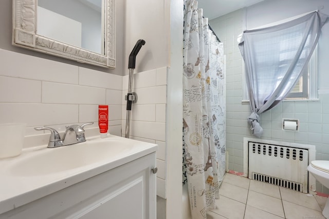 bathroom with walk in shower, tile patterned floors, radiator, and tile walls