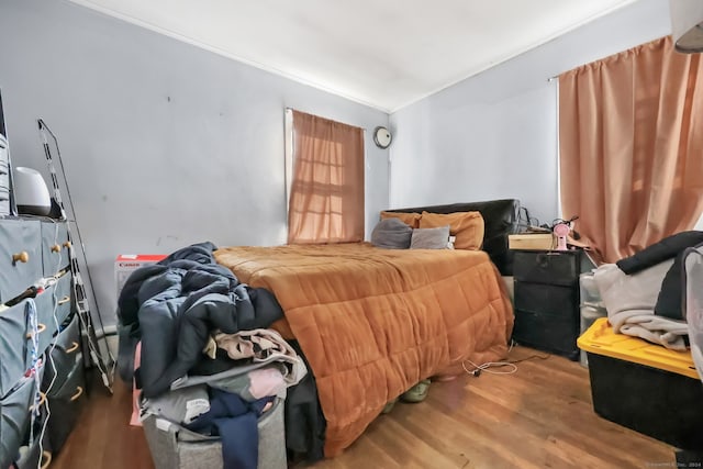 bedroom with hardwood / wood-style floors and ornamental molding