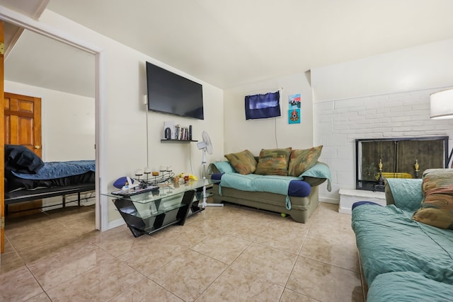 living room with tile patterned flooring and a brick fireplace