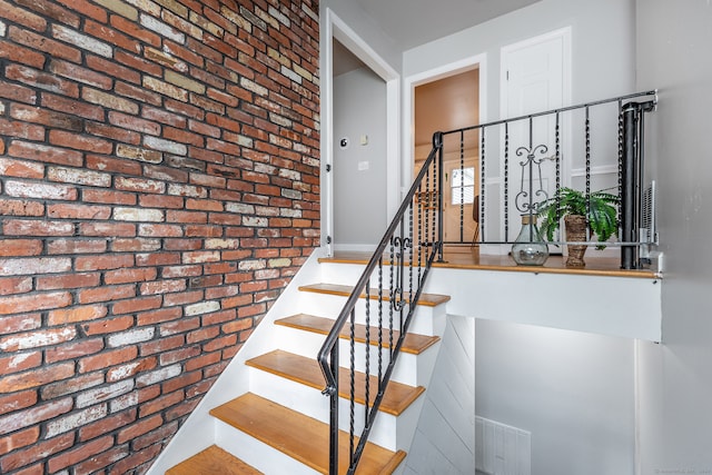 staircase with brick wall