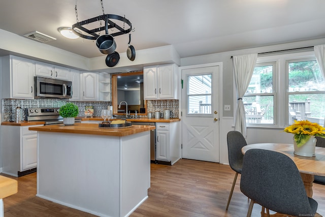 kitchen featuring white cabinetry, wood counters, and stainless steel appliances