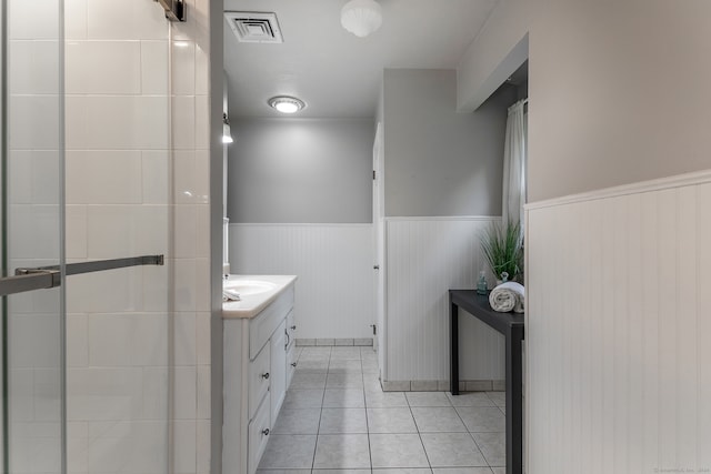 bathroom with walk in shower, tile patterned flooring, and vanity