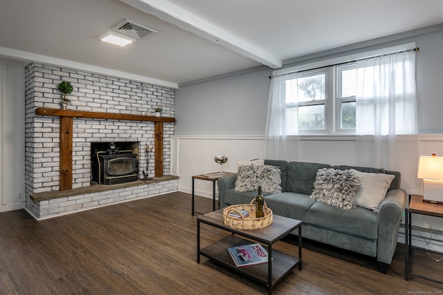 living room featuring ornamental molding, beam ceiling, dark hardwood / wood-style flooring, and a wood stove