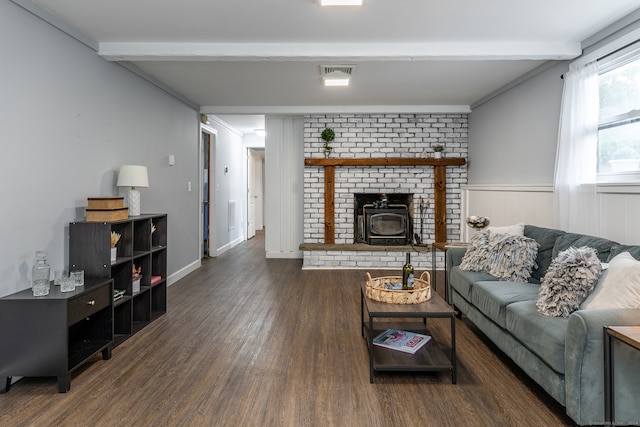 living room with dark hardwood / wood-style floors, beamed ceiling, and a wood stove