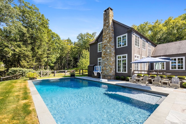 view of pool with a patio and a yard