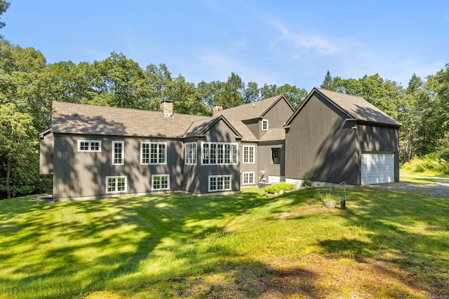 back of property featuring a lawn and a garage