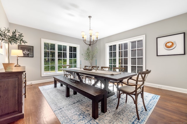 dining space featuring an inviting chandelier and dark hardwood / wood-style flooring