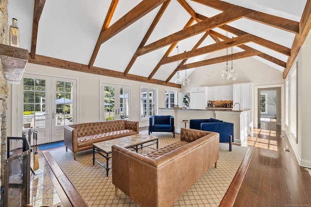 living room featuring light hardwood / wood-style floors, beamed ceiling, a notable chandelier, high vaulted ceiling, and french doors