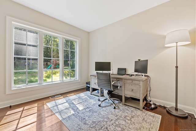 office space featuring wood-type flooring and a healthy amount of sunlight