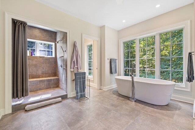 bathroom with a healthy amount of sunlight and shower with separate bathtub