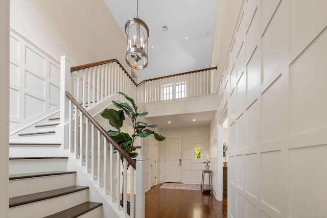 entryway with a notable chandelier, dark hardwood / wood-style floors, and a high ceiling