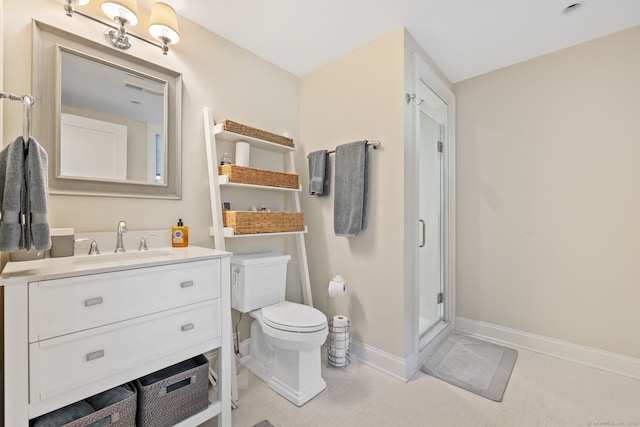 bathroom featuring vanity, toilet, and a shower with door