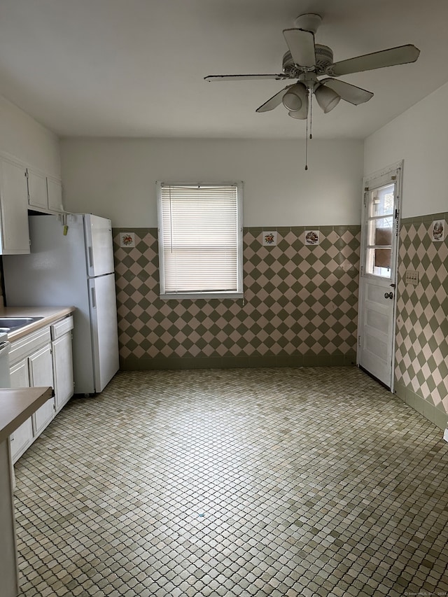 kitchen with white cabinetry, a healthy amount of sunlight, ceiling fan, and white fridge