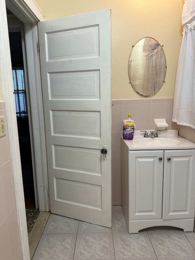 bathroom featuring tile patterned flooring, vanity, tile walls, and decorative backsplash