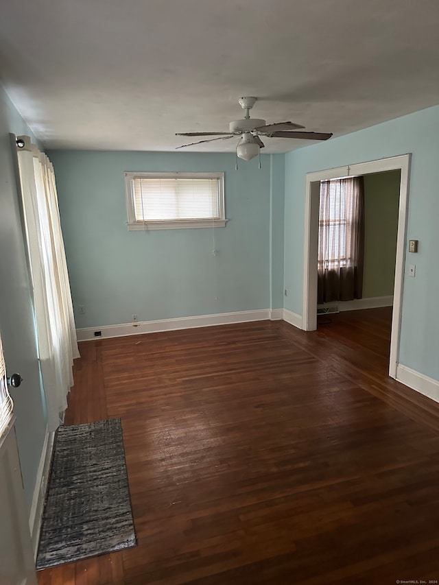 empty room with ceiling fan and dark hardwood / wood-style floors