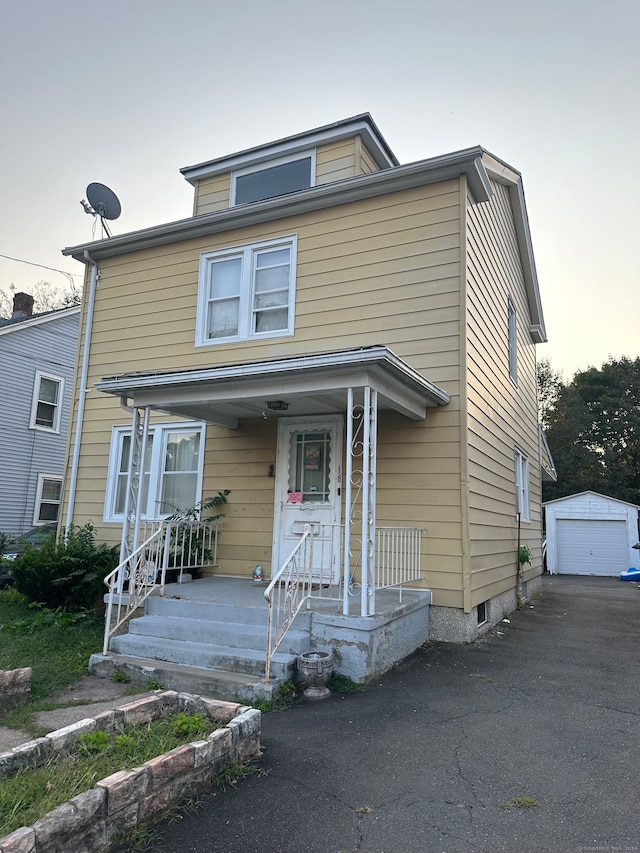 view of front of home featuring an outdoor structure, a garage, and a porch