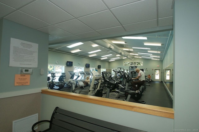 exercise room featuring a drop ceiling and vaulted ceiling