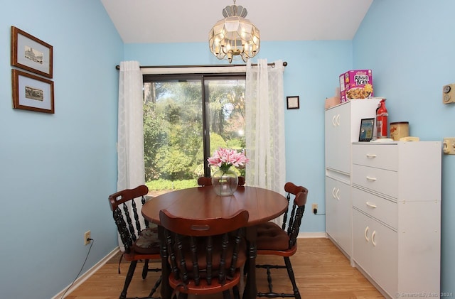 dining space with light hardwood / wood-style floors and a chandelier