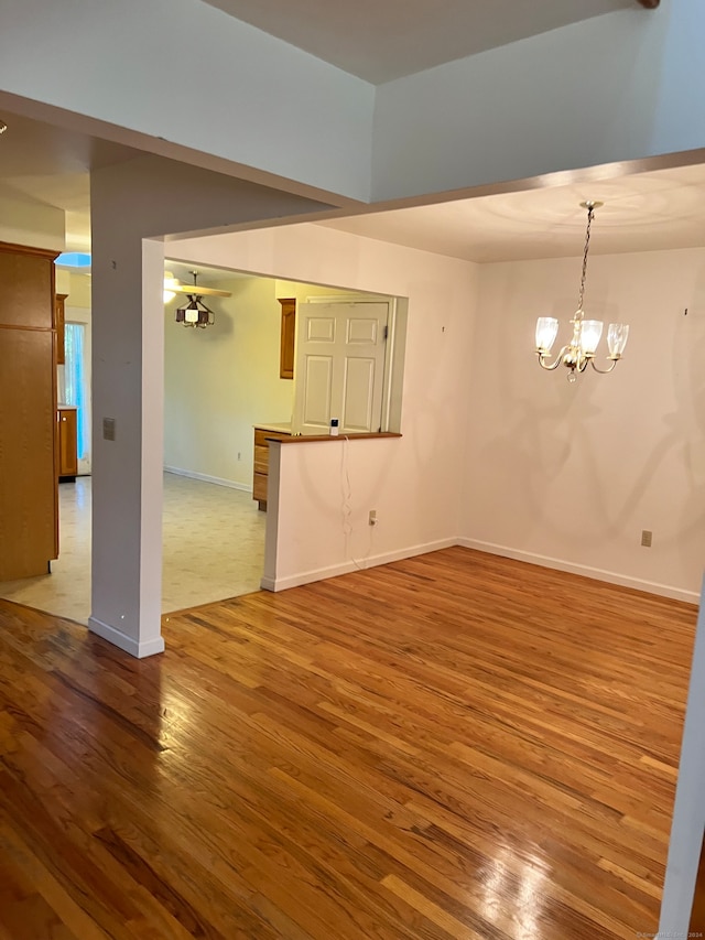 empty room featuring hardwood / wood-style floors and a chandelier