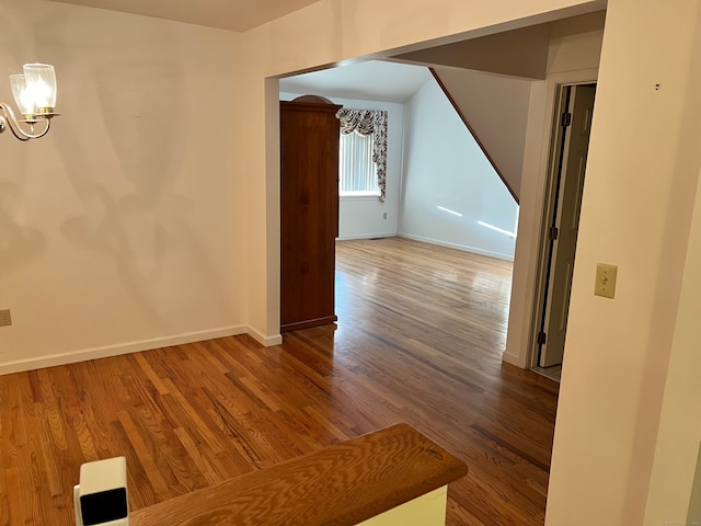 corridor featuring a notable chandelier and hardwood / wood-style flooring