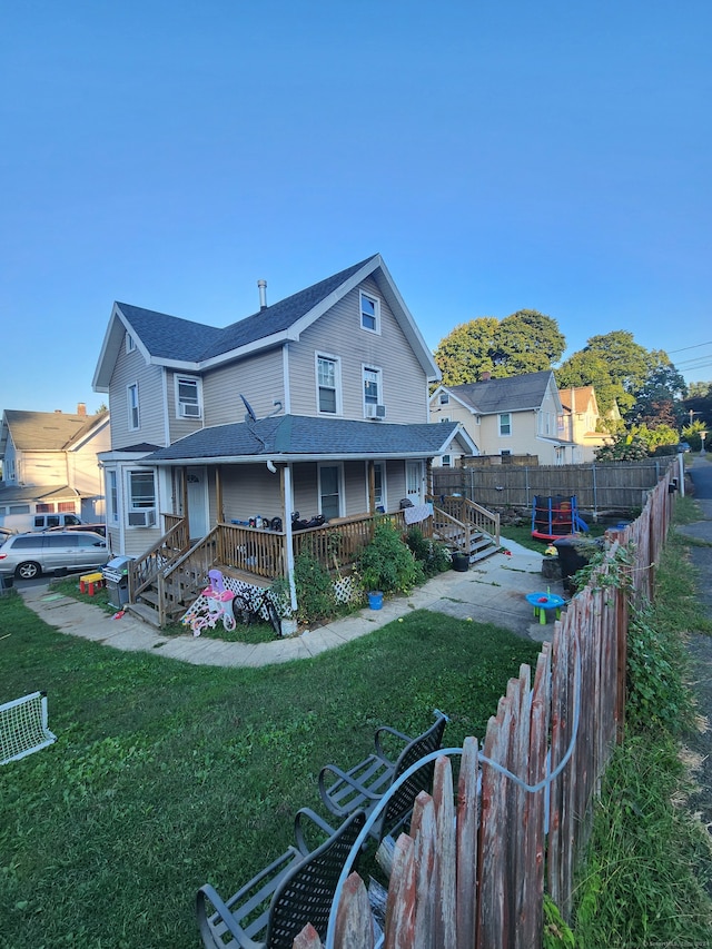 rear view of property featuring a lawn and cooling unit