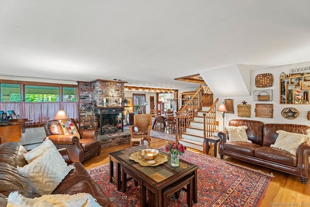 living room featuring a brick fireplace and wood-type flooring